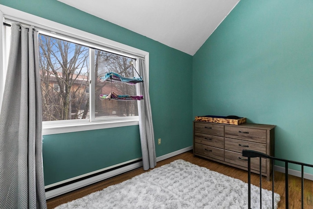 bedroom with a baseboard heating unit, lofted ceiling, wood finished floors, and baseboards