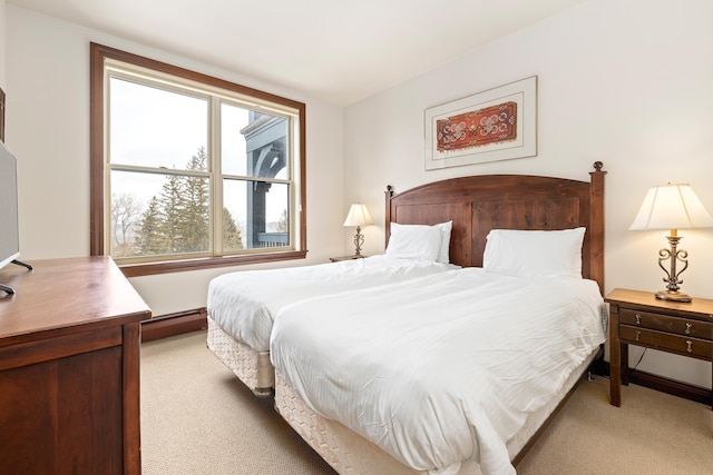 bedroom with light colored carpet and baseboard heating