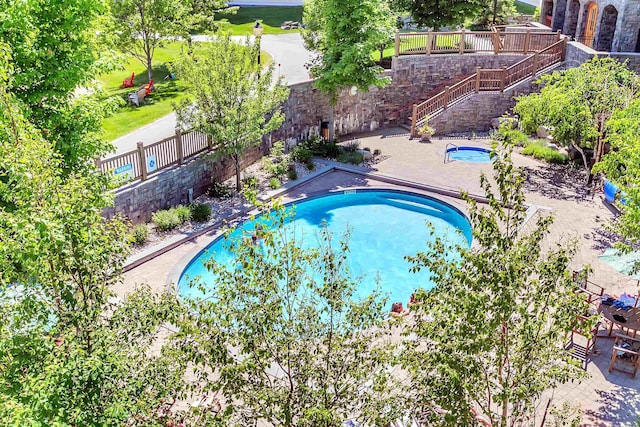 pool with stairs, a patio area, a fenced backyard, and an in ground hot tub