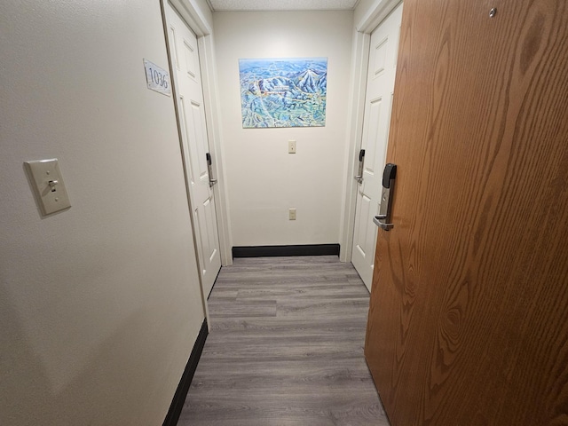 entryway with wood finished floors and baseboards