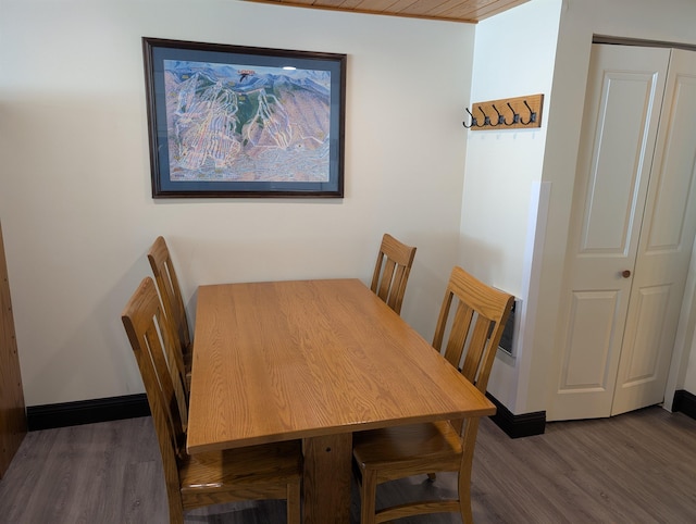 dining space with baseboards and wood finished floors