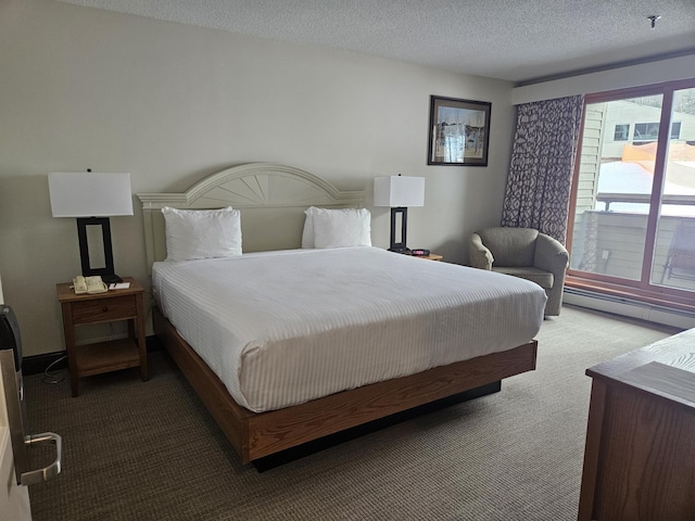 carpeted bedroom with a textured ceiling and a baseboard heating unit