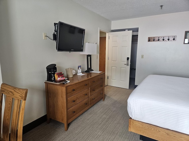 bedroom featuring a textured ceiling, baseboards, and light carpet