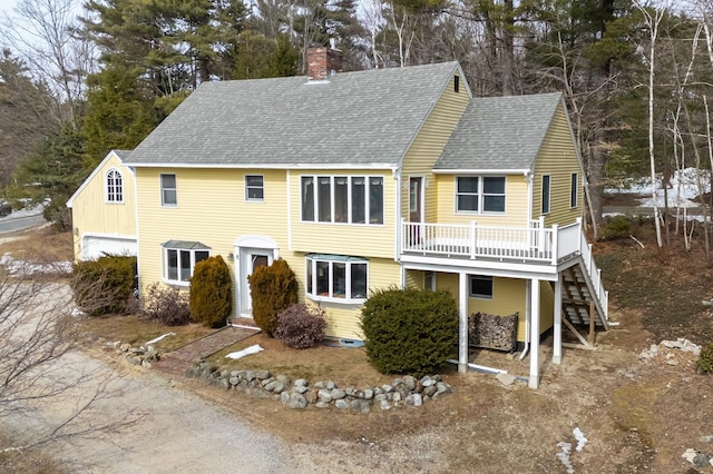 39 Birch Glen Dr, Bennington, NH 03442 - view of front facade featuring a chimney, a deck, roof with shingles, a garage, and stairs