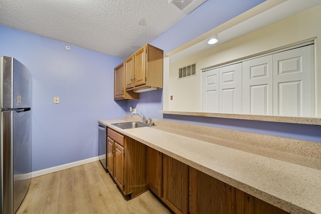 kitchen with light countertops, visible vents, appliances with stainless steel finishes, and a sink