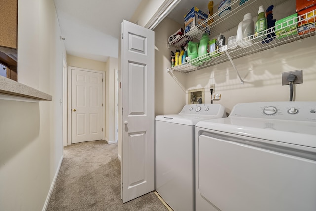 clothes washing area featuring baseboards, light colored carpet, independent washer and dryer, and laundry area