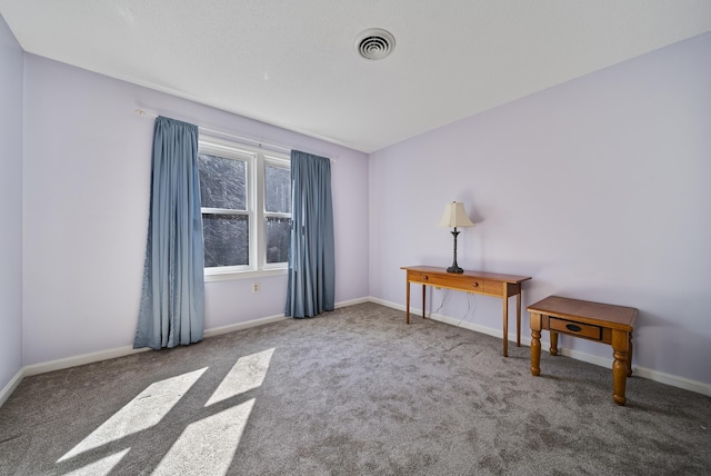 spare room with carpet flooring, baseboards, and visible vents