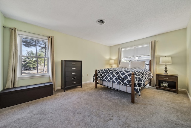 carpeted bedroom with visible vents, baseboards, and a textured ceiling