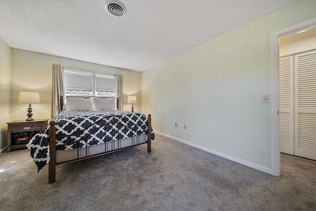 carpeted bedroom with visible vents, a textured ceiling, and baseboards