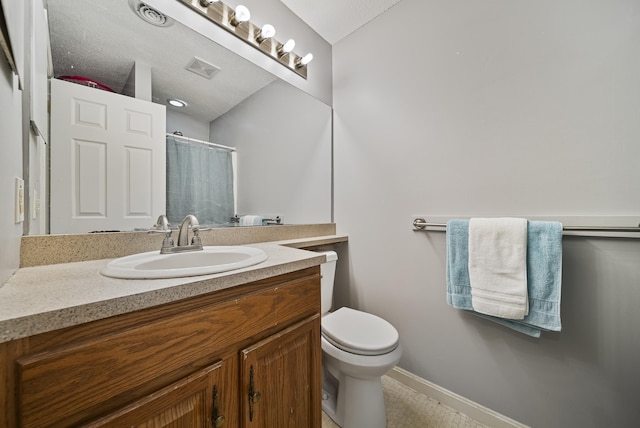 bathroom featuring a shower with shower curtain, toilet, vanity, and baseboards