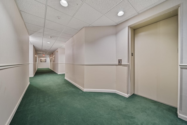 interior space featuring a drop ceiling, elevator, baseboards, and carpet flooring