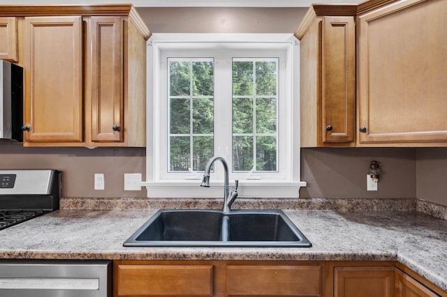 kitchen with a sink, plenty of natural light, appliances with stainless steel finishes, and light countertops