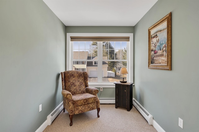 sitting room featuring a baseboard heating unit, baseboards, and light carpet