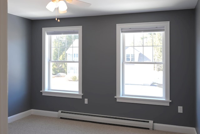 carpeted spare room with a baseboard heating unit, a healthy amount of sunlight, baseboards, and a ceiling fan