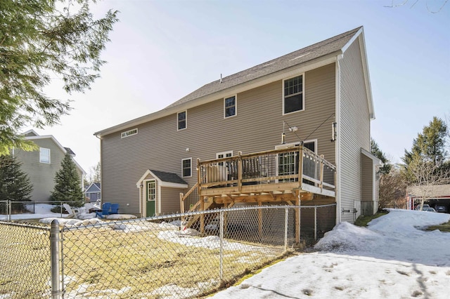 snow covered property with fence and a wooden deck