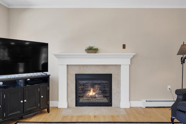 living area featuring baseboard heating, a fireplace, light wood-style floors, and ornamental molding