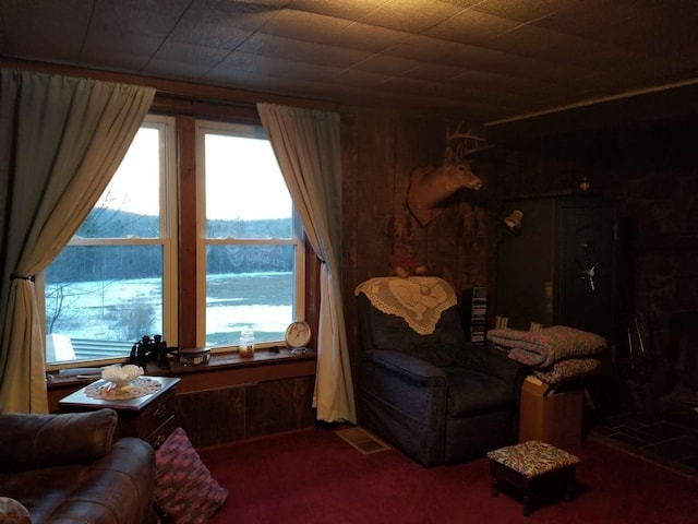 living room featuring visible vents and wooden walls