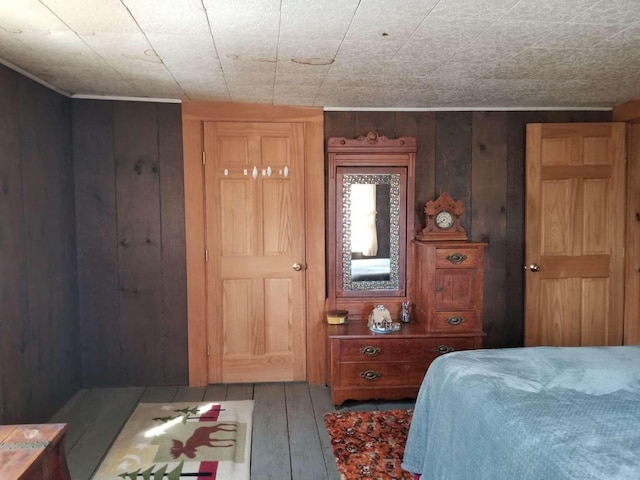 bedroom featuring wood walls and hardwood / wood-style flooring