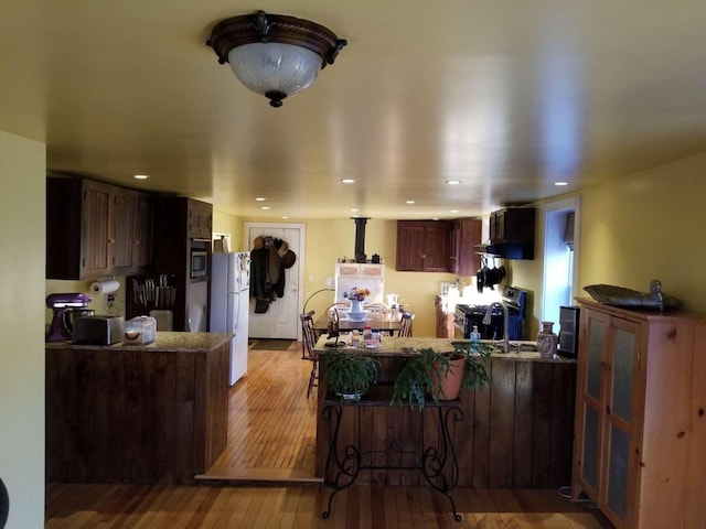 kitchen featuring a peninsula, light wood-style flooring, recessed lighting, a sink, and appliances with stainless steel finishes