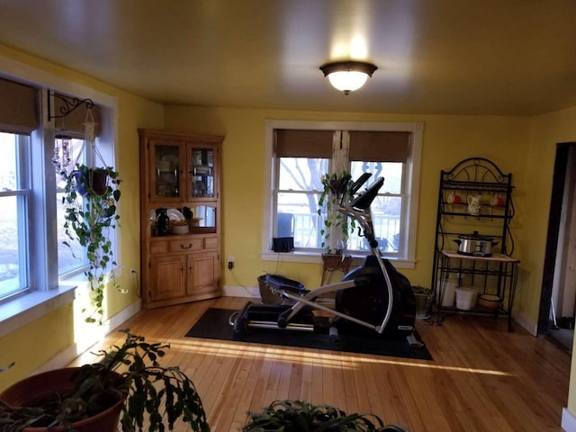 exercise area with light wood-style flooring and baseboards