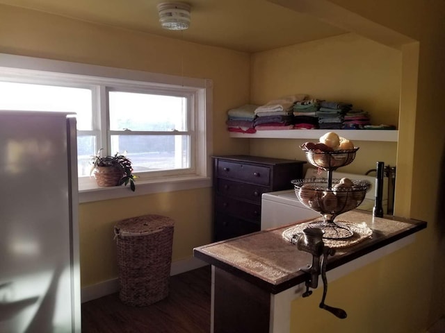 laundry area with wood finished floors and baseboards