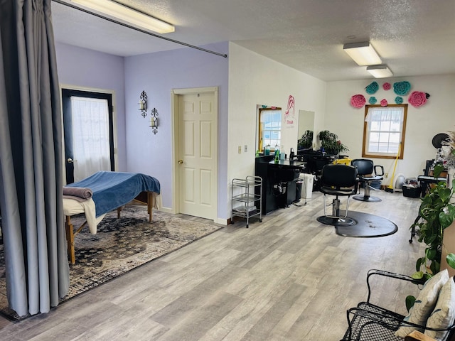 office area with baseboards, a textured ceiling, and wood finished floors