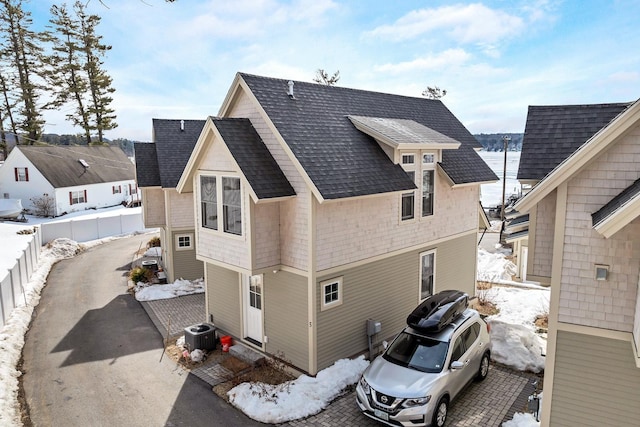 109 Weirs Blvd Unit 5, Laconia, NH 03246 - snow covered rear of property featuring a shingled roof and central AC unit