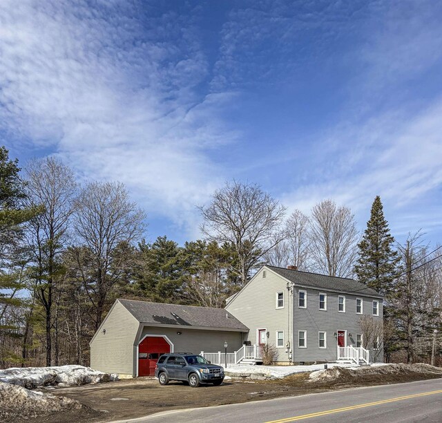 view of front of house featuring driveway, a chimney, and a garage