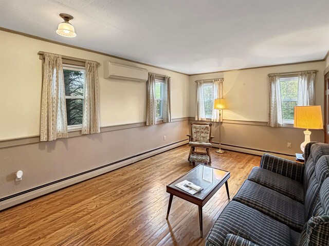 living room with a wall mounted air conditioner, a baseboard heating unit, a wealth of natural light, and wood finished floors