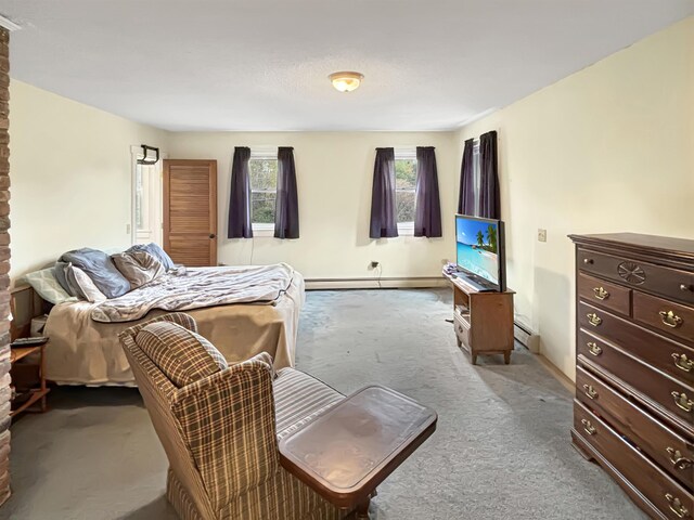 carpeted bedroom with a baseboard heating unit and baseboard heating