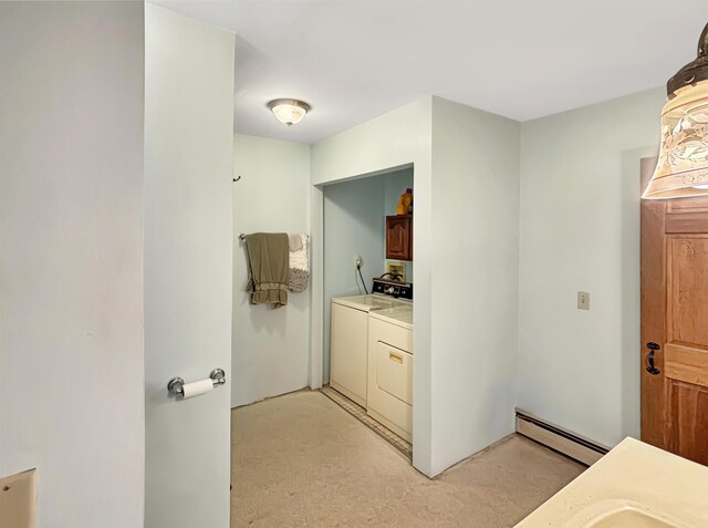 bathroom with a baseboard heating unit, vanity, and washing machine and dryer