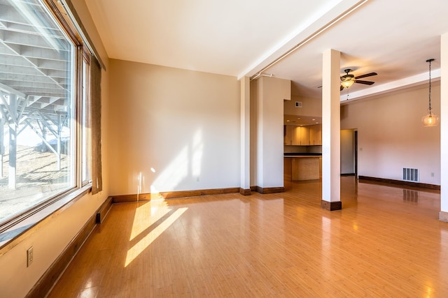 unfurnished room featuring visible vents, baseboards, ceiling fan, and wood finished floors