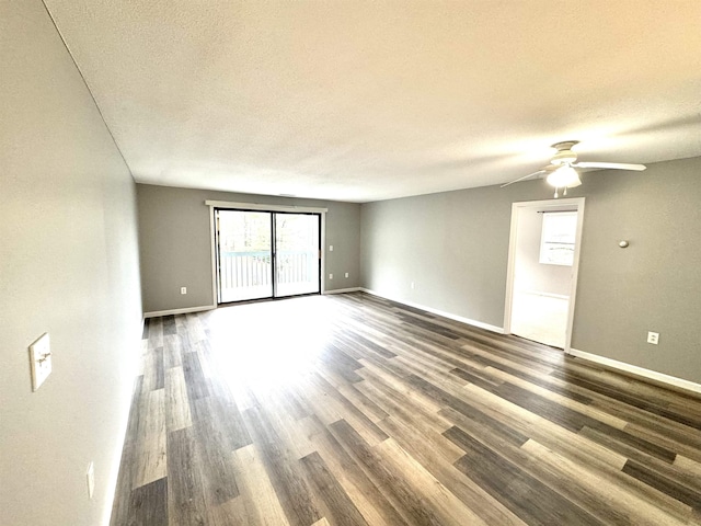 unfurnished room with ceiling fan, baseboards, a textured ceiling, and wood finished floors