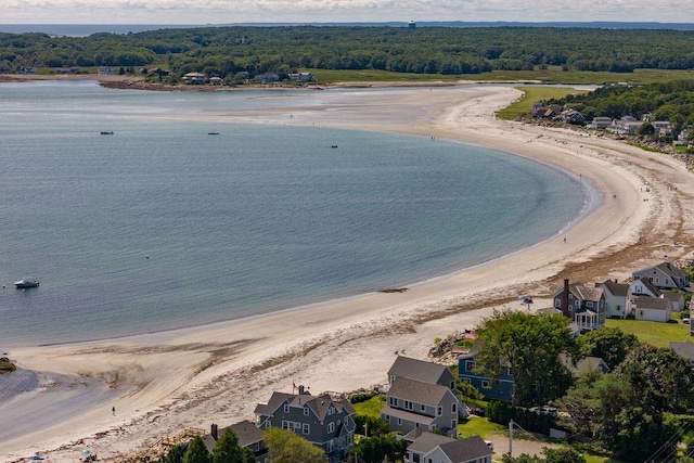 aerial view with a forest view, a view of the beach, and a water view