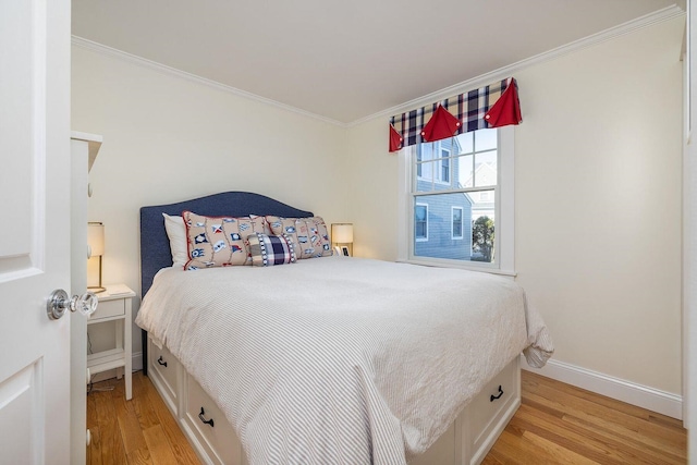 bedroom featuring baseboards, light wood finished floors, and ornamental molding