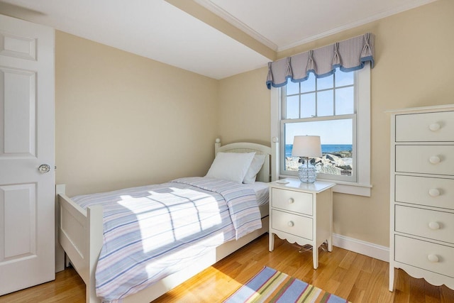 bedroom featuring light wood-type flooring, baseboards, and crown molding