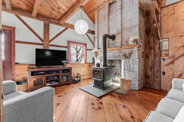 882 Mitchell Rd, Shrewsbury, VT 05738 - living room featuring wooden walls, beam ceiling, a wood stove, hardwood / wood-style flooring, and wooden ceiling