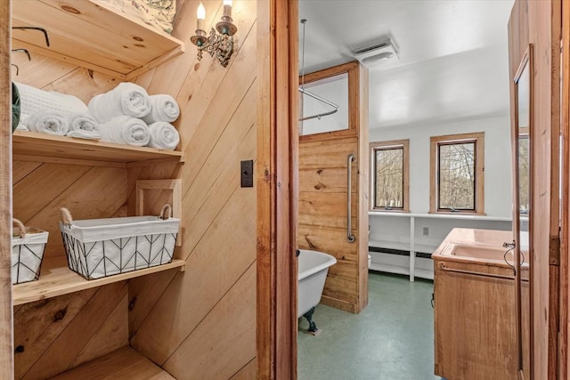 882 Mitchell Rd, Shrewsbury, VT 05738 - bathroom with visible vents, vanity, a freestanding bath, and concrete flooring
