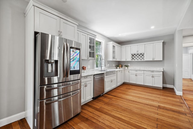 51 E Derry Rd, Derry, NH 03038 - kitchen featuring baseboards, light wood finished floors, a sink, glass insert cabinets, and appliances with stainless steel finishes