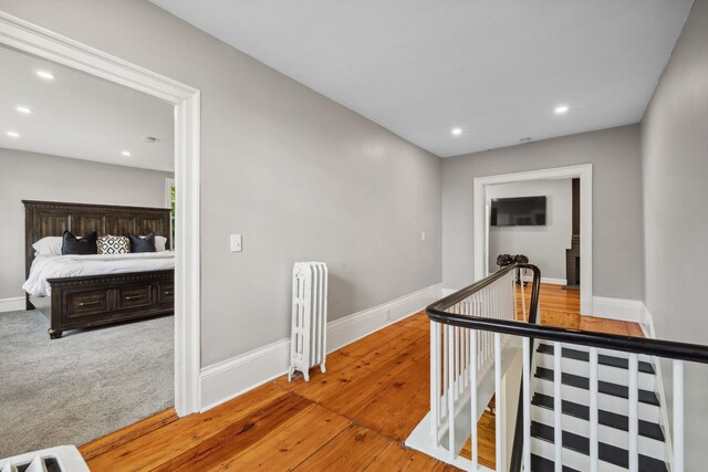 51 E Derry Rd, Derry, NH 03038 - hall with radiator, wood finished floors, baseboards, recessed lighting, and an upstairs landing