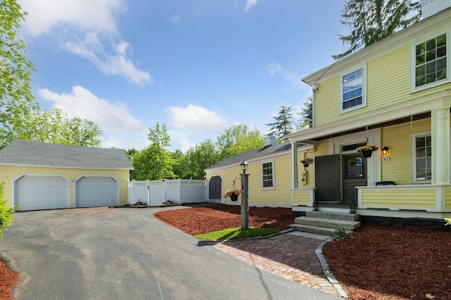 51 E Derry Rd, Derry, NH 03038 - view of front of house featuring covered porch, a detached garage, and fence