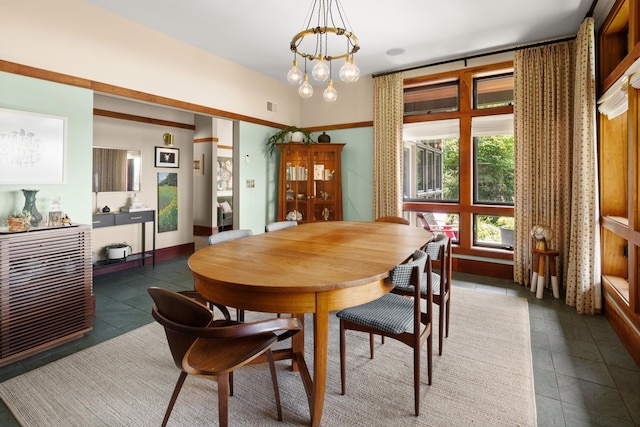 dining area featuring a notable chandelier, visible vents, and dark tile patterned flooring