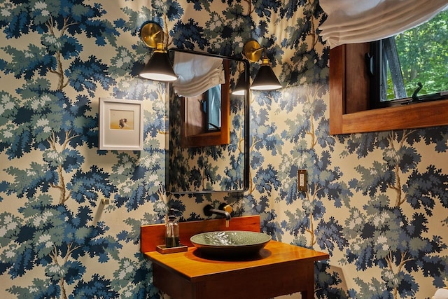 bathroom featuring wallpapered walls and vanity
