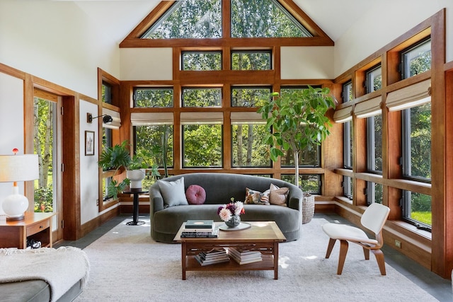 sunroom featuring carpet floors and high vaulted ceiling