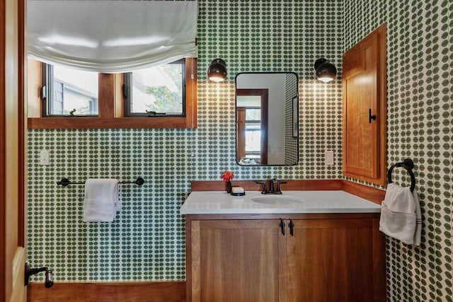bathroom with wallpapered walls, vanity, and a wealth of natural light