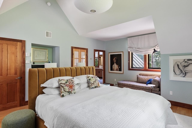 bedroom with high vaulted ceiling, wood finished floors, visible vents, and baseboards