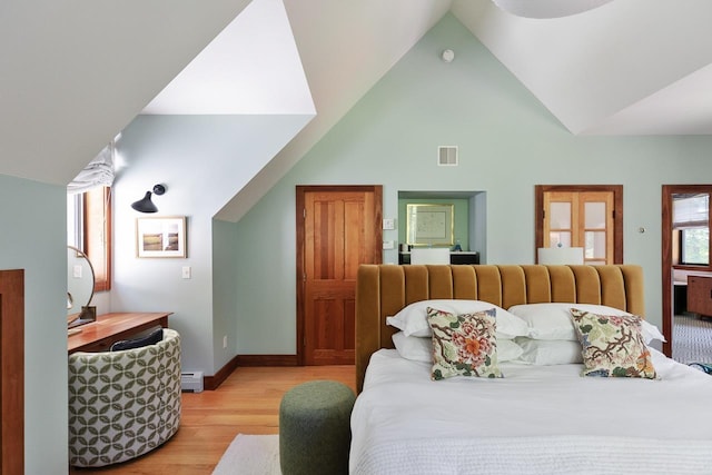 bedroom with visible vents, high vaulted ceiling, light wood finished floors, a baseboard radiator, and baseboards