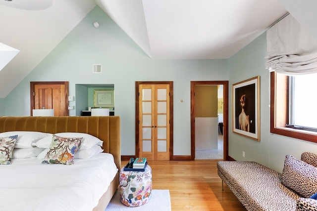 bedroom with lofted ceiling, visible vents, and light wood-type flooring