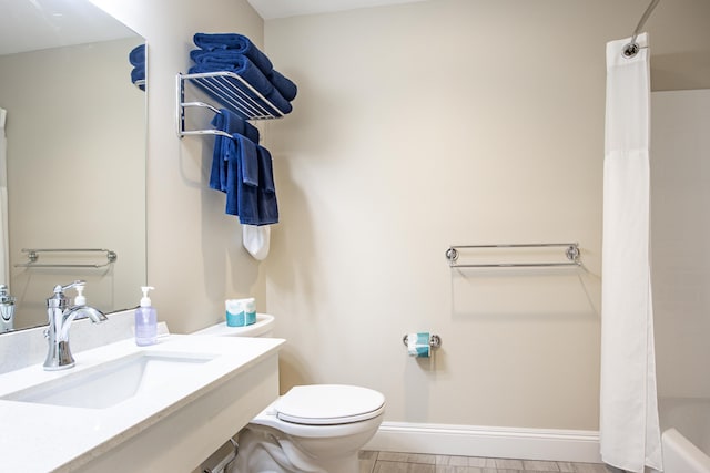 bathroom with curtained shower, toilet, baseboards, and a sink