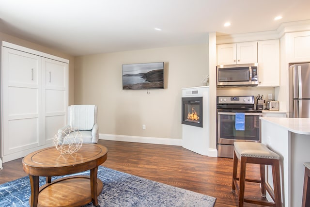 kitchen featuring dark wood-style floors, appliances with stainless steel finishes, light countertops, and baseboards